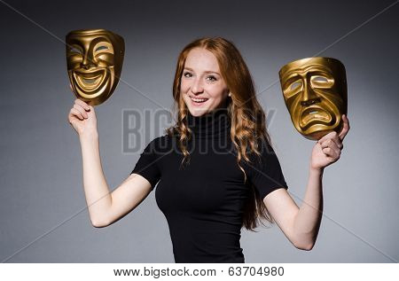 Redhead woman iwith masks in hypocrisy consept against grey background