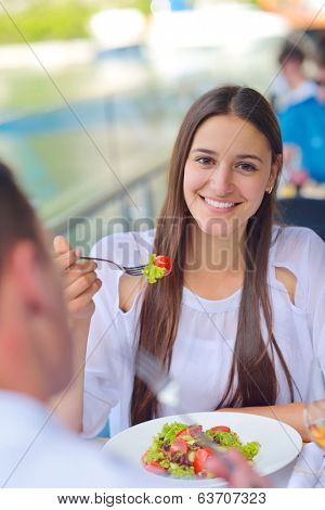 happy young couple having lanch at beautiful restaurant on by the sea on  beach