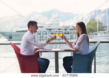 happy young couple having lanch at beautiful restaurant on by the sea on  beach