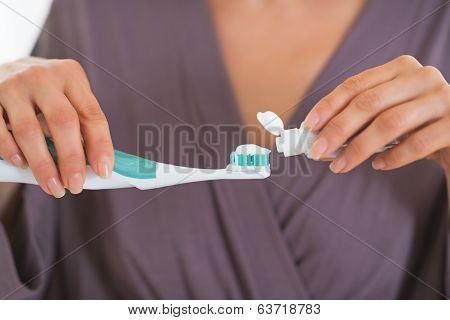 Closeup On Young Woman Squeezing Toothpaste On Toothbrush