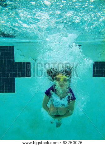underwater view of girl jumping into pool