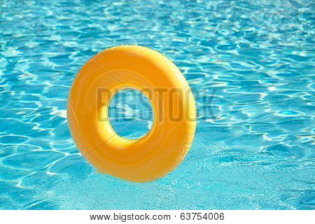 floating ring on blue water swimpool with waves reflecting in the summer sun