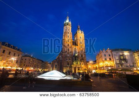 KRAKOW, POLAND - APR 7, 2014: St. Mary's Church on Rynek Glowny (Market Square) in night time. Rynek Glowny - roughly 40,000 m2 is largest medieval town square in Europe.
