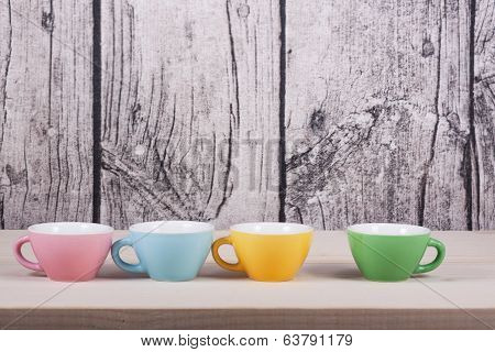 Cups On Table Over Wooden Background
