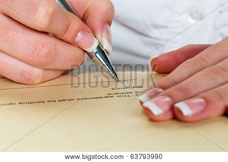 a woman signs a contract or a will with a fountain pen.