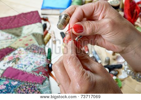 A Woman Threader The Wire In A Needle