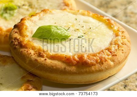 Pizzette mini Italian pizzas served with fresh basil leaves