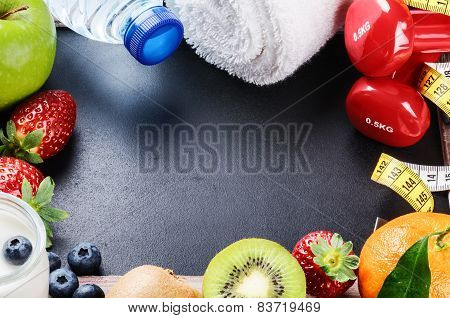 Fitness Frame With Dumbbells, Towel And Fresh Fruits