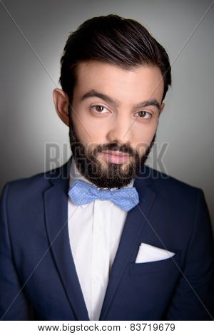 Stylish man with beard and bow tie looking at camera