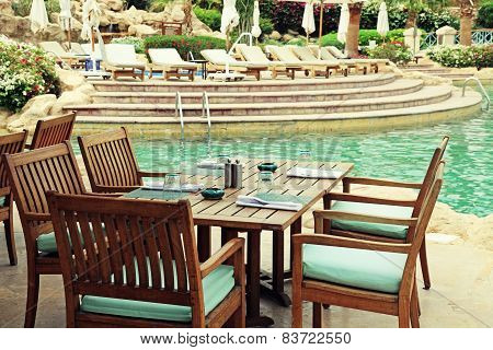 Table And Chairs In Outdoor Cafe Next To The Resort Swimming Pool