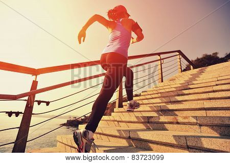 healthy lifestyle sports woman running up on stone stairs sunrise seaside