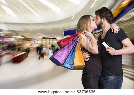 Happy Kissing Couple With Shopping Bags In The Mall