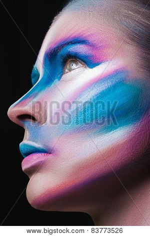 Beautiful fashion woman with bright color face art and body art. Paint on face. Creative portrait
