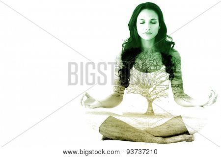 Pretty brunette doing yoga against tree in showy field