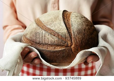 Woman holding tasty fresh bread, close up