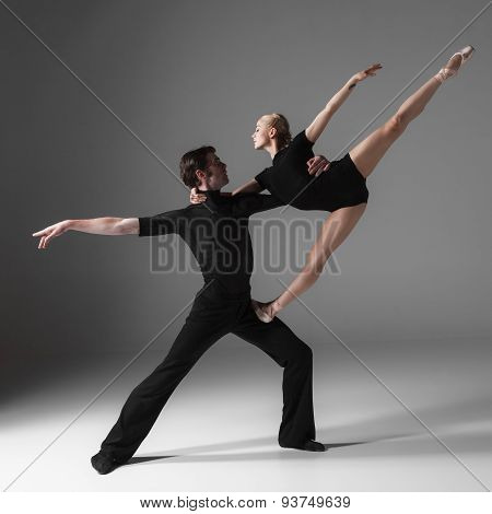 two young modern ballet dancers on gray studio background