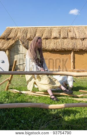Shepherdess Tending A Goat In The Backyard Of A Clay Hut