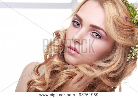 Beautiful girl, isolated on a light - grey background with varicoloured flowers in hairs, emotions, cosmetics