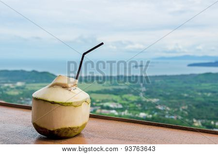 Fresh coconut water drink in cafe with seaview