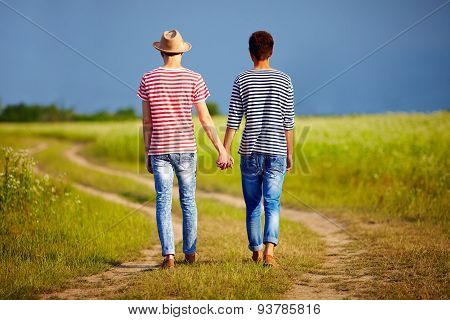 Young Male Couple Walking Away On Summer Field Path