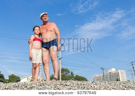 Grandfather with his granddaughter on the railway embankment
