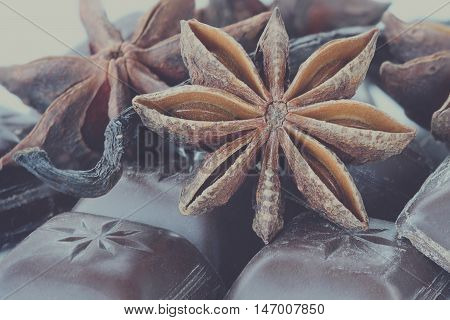 Close up of Star of Anise Chocolate bars and Vanilla pods. Extreme close-up with shallow depth of field. Selective focus on center of Anise star.