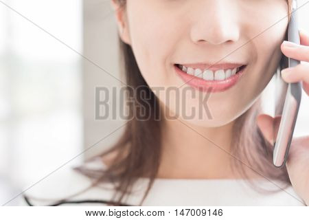 woamn talk on phone with white wall asian