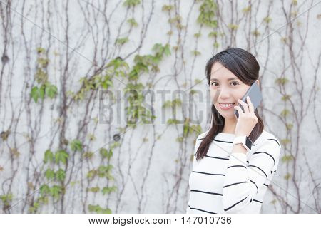 woamn talk on phone with white wall asian