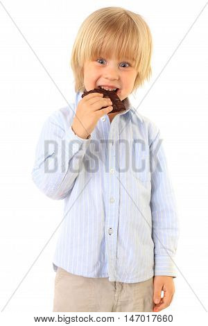 happy kid with light hair eating black tasty chocolate