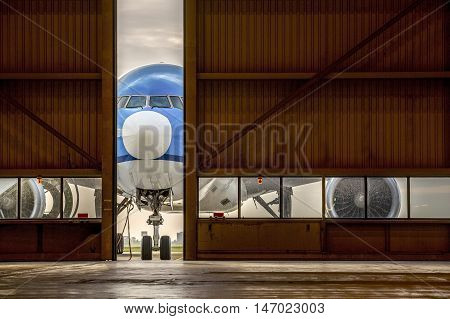Airplane In Front Of Half Opened Door To Hangar