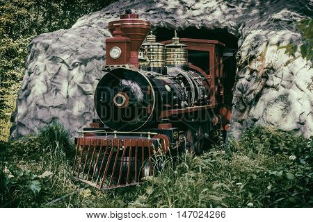 steam train leaves the tunnel. vintage. Children's locomotive and train in the park.