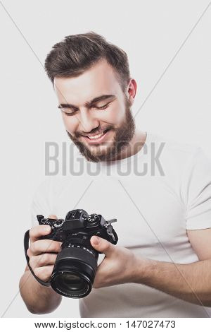 young bearded photographer taking pictures with digital camera.