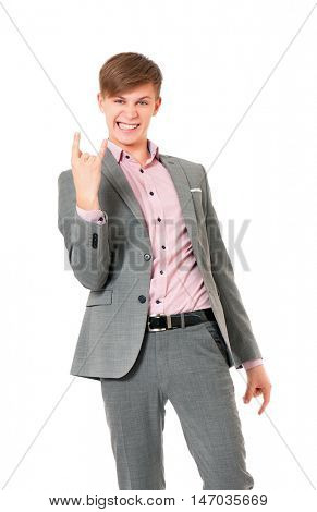 Young man doing a rock gesture. Portrait of a confident businessman looking at camera. Handsome boy in gray suit isolated on white background. 