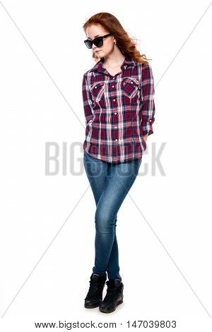 Beautiful girl in sunglasses in a full-length isolated on white background. Young pretty curly woman in plaid shirt and jeans posing