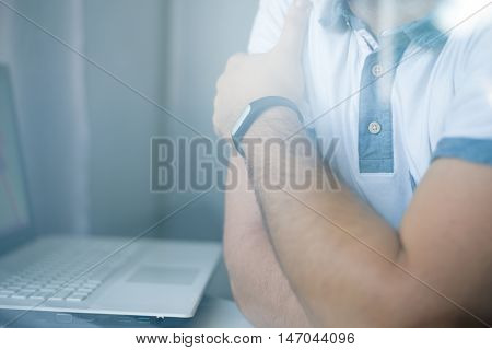 Closeup Of Man With Fitness Tracker In The Office Through Glass Window