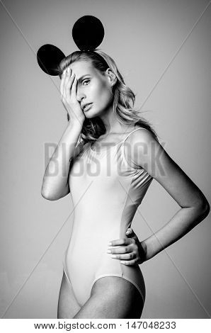Blonde girl wearing bodysuit and black mouse ears, black and white photo