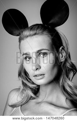 Blonde girl wearing bodysuit and black mouse ears, black and white photo
