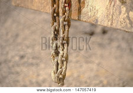 HDR old chain hangs on a excavator in a concrete plant