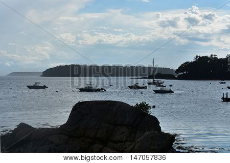 Boats silhouetted in the harbor of Bustin's Island Maine.