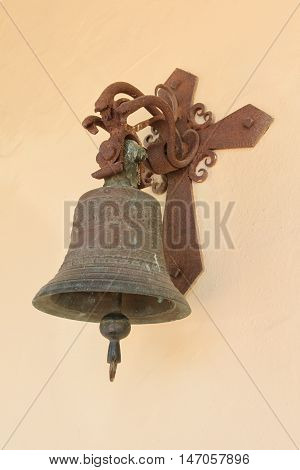An old bell at the wall of a church.