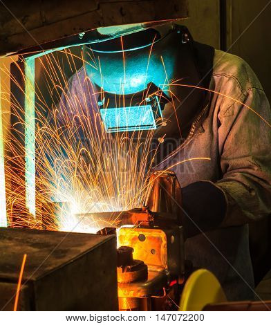 Employee welding Industrial automotive part in factory