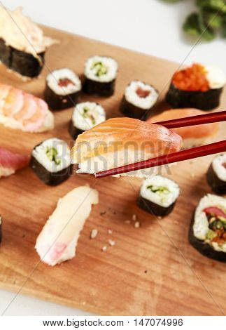 Chopsticks with Nigri Sushi and Sushi Plate in Background
