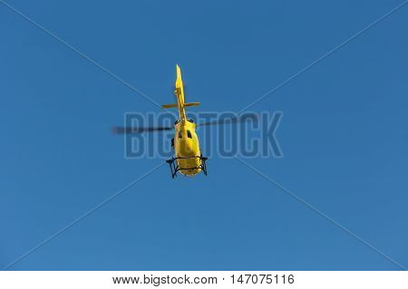 Medical rescue helicopter flying rescue injured climber on the Tre Cime. Italy, Dolomites