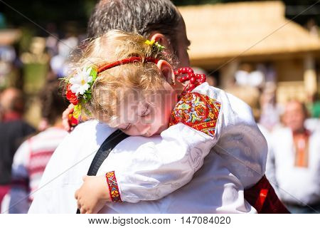 4 September 2016. Rakhiv Transcarpathian region Ukraine. Celebration - Festival Hutsul brynza - shepherds and sheep return from mountains. Father and baby daughter in national costumes