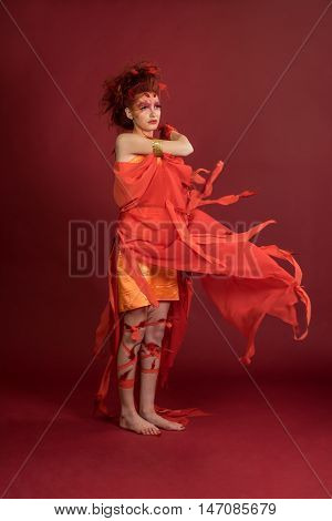 Phoenix woman. Flaming young girl on the red background