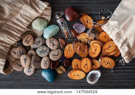 wooden, rune stone with his own hands among the crystals on a dark background