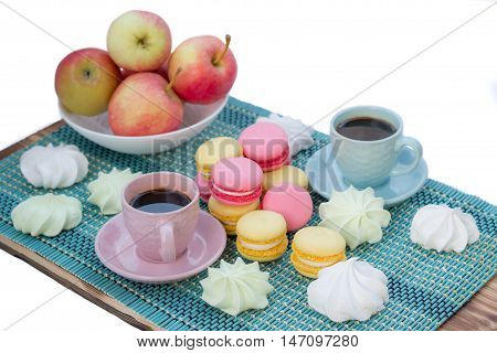 Still life of served coffee cups macaroon cookies marshmallows and apples