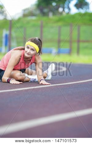 Sport Concepts and Ideas. Caucasian Brunette Female in Athletic Sportgear Having Legs Stretching Excercises Outdoors.Vertical Shot