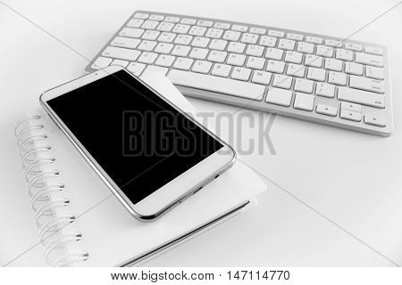 office table with notebook, computer keyboard and smartphone. copy space
