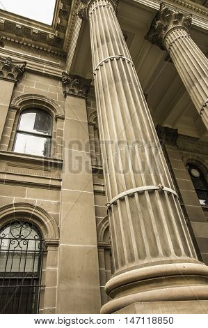 Historical large yellow sandstone building with Roman columns